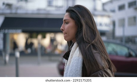 One anxious Middle Eastern young woman walking in street feeling frustrated. Female person in 20s suffering from mental pressure in urban environment sidewalk - Powered by Shutterstock