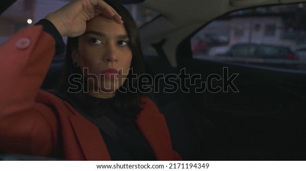 One\
anxious woman in backseat of a car stuck in\
traffic