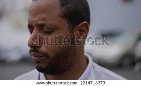 One anxious young African American man in distress closeup face. Portrait of a black person with worried preoccupied emotion