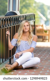 One Attractive Blonde Hair Caucasian High School Senior Posing For Senior Pictures. Female Teenager Portrait Outdoors At Park In Summer.