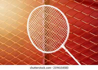 One Badminton Racket Is Hung On Red Grill By A Cable Tie For Display In Exhibition Sports Event