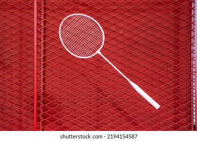 One Badminton Racket Is Hung On Red Grill By A Cable Tie For Display In Exhibition Sports Event