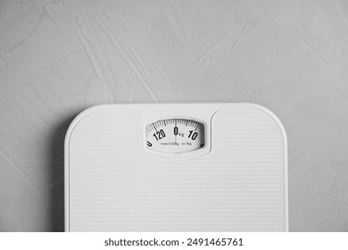 One bathroom scale on grey textured background, top view. Space for text