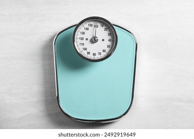 One bathroom scale on white wooden background, top view