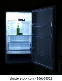 One  Beer Bottle And Canned Tune In Open Empty Refrigerator: Bachelor Fridge Concept.