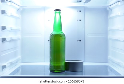 One  Beer Bottle And Canned Tune In Open Empty Refrigerator: Bachelor Fridge Concept.