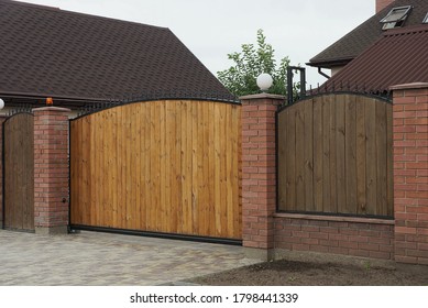 one big closed brown private gate and part of the fence from wooden boards
