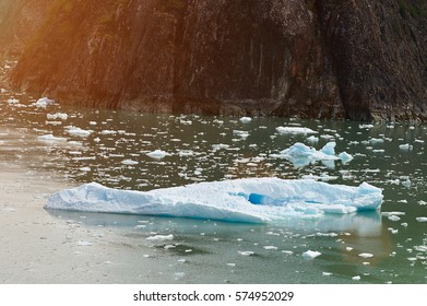 One big iceberg float next to big rock. Alaska  boat tour in glacier