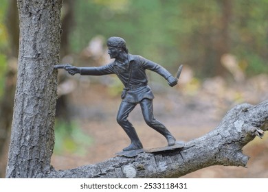 one big old dirty brown toy soldier stands on a tree branch in a summer park - Powered by Shutterstock