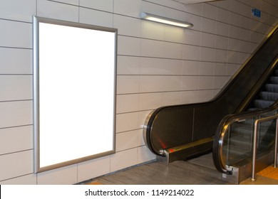 One big vertical / portrait orientation blank billboard with escalator background in public transport