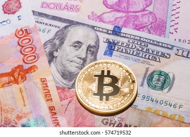 One Bitcoin on multicurrency banknotes. Closeup, Macro shot