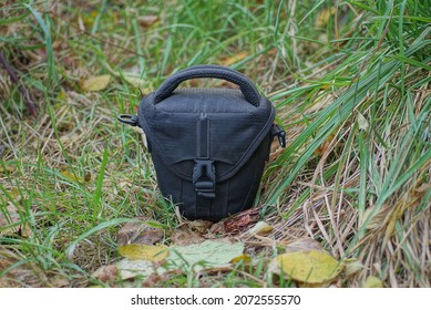 One Black Dirty Closed Bag A Wardrobe Trunk Made Of Fabric Stand On The Grass And Fallen Leaves In Nature