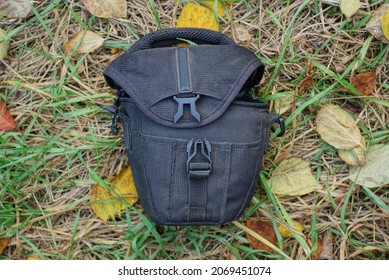 One Black Dirty Open Bag A Wardrobe Trunk Made Of Fabric Lies On The Grass And Fallen Leaves In Nature