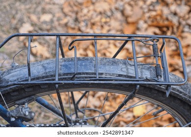 one black metal trunk above the wheel of a sports bike on the street on a brown background - Powered by Shutterstock