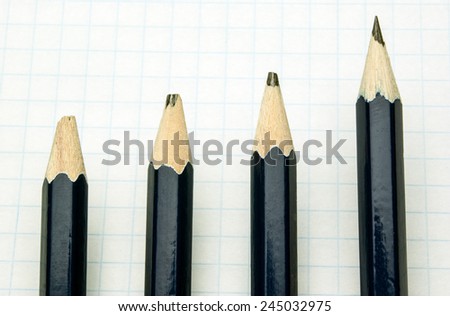 one blue pencil and three blunt pencil on a white sheet of paper in a cage