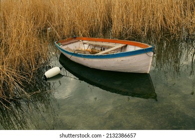 one boat moored near reed grass on Lake Ohrid during a cloudy day