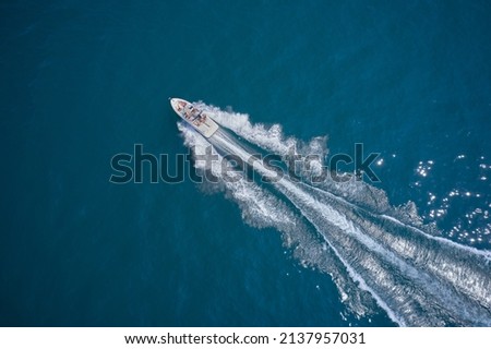 One boat on blue water drone view. Modern boat in motion making a trail on the water top view. Boat moving fast aerial view.
