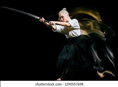 one bodokas fighters woman practicing Iaido  Kenjutsu  studio shot isolated on black background