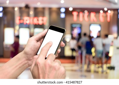 One Booking Movie Ticket Via Smart Phone. Ticket Selling Machine In The Background