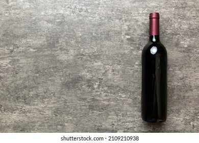 One Bottle Of Red Wine On Colored Table. Flat Lay, Top View Wth Copy Space.