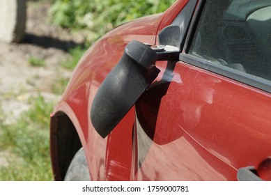 One Broken Black Plastic On A Red Passenger Car In The Street