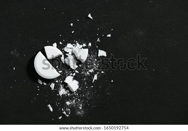 One broken\
white pill on black background macro photo - concept of medicine\
and medication treatment, health\
care