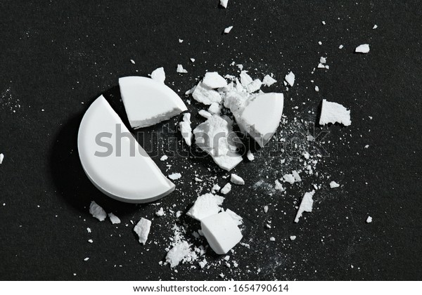 One broken\
white pill on black background macro photo - concept of medicine\
and medication treatment, health\
care