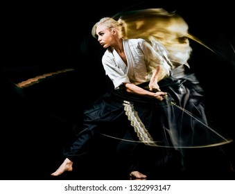one budokas fighters woman practicing Iaido  Kenjutsu  studio shot isolated on black background