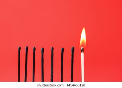 One burning match among burnt-out ones on color background. Concept of uniqueness