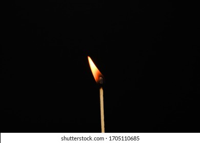 One burning matchstick on a black background