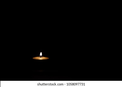 One Candle Burning On A Dark Background Of Sorrow And Memory
