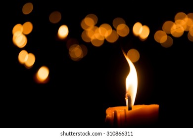 One candle flame light at night with bokeh on dark background - Powered by Shutterstock