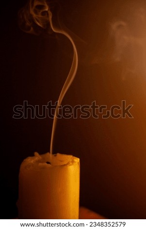 one candle smoking in the dark