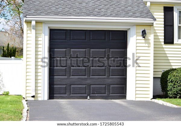 One car Garage Door painted in black color on a
typical single house