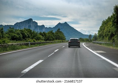 One Car On The Austrian Autobahn On A Summer Day With The Alps In The Background