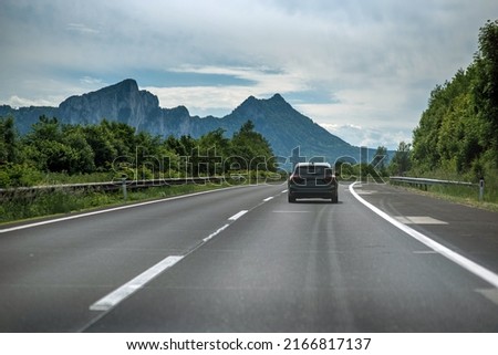 One car on the Austrian Autobahn on a summer day with the Alps in the background