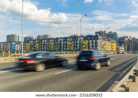 One car overtakes another on the street. Motion blur