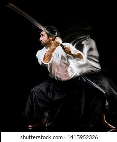 one caucasian bodoka fighters man practicing Iaido  Kenjutsu studio shot isolated on black background