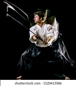 one caucasian bodoka fighters man practicing Iaido Kenjutsu studio shot isolated on black background