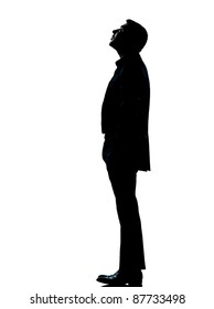 one caucasian business man silhouette standing looking up Full length in studio isolated on white background