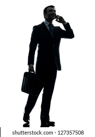 One Caucasian Businessman Walking On The Telephone In Silhouette Studio Isolated On White Background