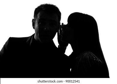 one caucasian couple man and woman  whispering at ear in studio silhouette isolated on white background