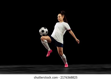 One caucasian energetic woman, soccer, football player in motion isolated on dark background. Sport, action, competitions, games and fitness concept. Young sportive wearing football kit. - Powered by Shutterstock