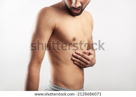 One Caucasian man feeling severe pain in his rib cage with worried face. Isolated in white background.