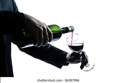 One Caucasian Man Hands Detail Pouring Red Wine In A Glass Silhouette In Studio Isolated White Background