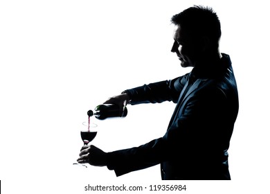 One Caucasian Man Portrait Pouring Wine In A Glass Silhouette In Studio Isolated White Background