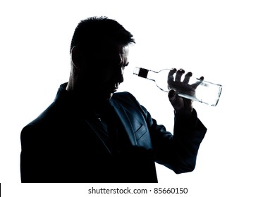 One Caucasian Man Portrait Silhouette Drunk Looking At An Empty Alcohol Botlle In Studio Isolated White Background