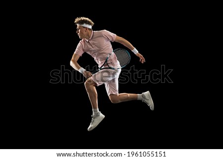 One Caucasian man, professional tennis player isolated on black background.