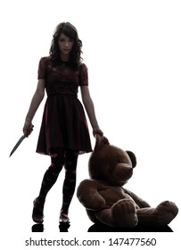 one caucasian strange young woman killer holding  bloody knife an teddy bear in silhouette white background