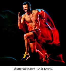 One Caucasian Topless Muscular Mature Man Runner. Running Jogger Jogging Isolated On Black Background With Light Painting Speed Mouvement Effect